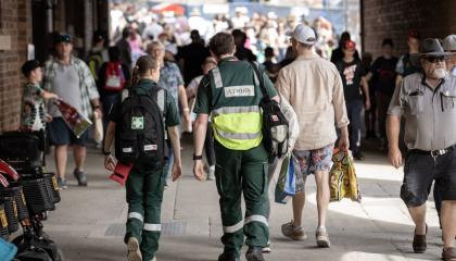 A photo of two St John volunteers walking through a crowd at Ekka.