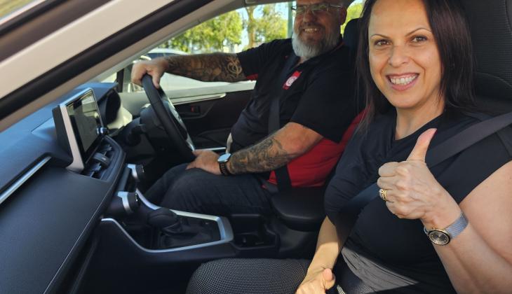 An image of community service workers in a vehicle, smiling.